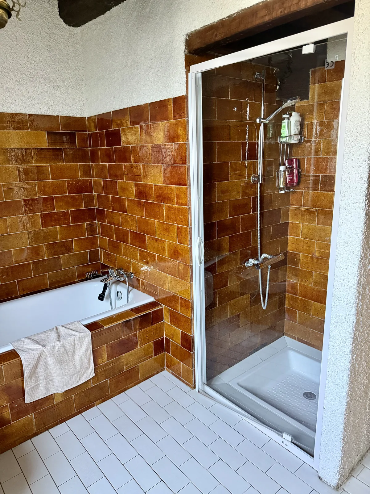 La salle de bain du premier étage de Maison Aline, sa baignoire et sa douche en faïence terracotta